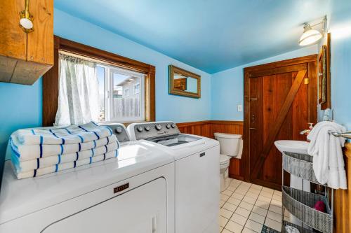 a bathroom with a washing machine and a toilet at Taylor Made Cottage in Bodega Bay