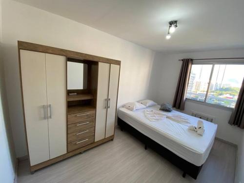 a bedroom with a bed and a dresser and a window at Solar carioca - beleza e conforto in Rio de Janeiro