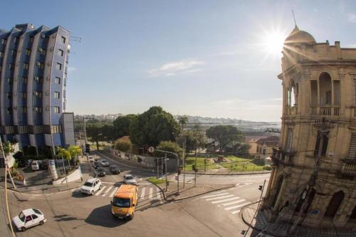 un autobús amarillo conduciendo por una calle al lado de un edificio en HOTEL MILANO, en Sorocaba