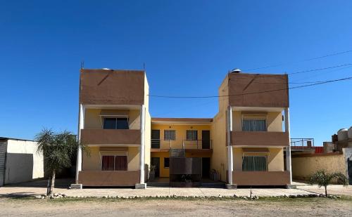 un edificio con 2 balcones en un lateral en Complejo “Aloe Vera” en Villa Dolores