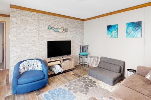 a living room with a tv and a couch and a chair at Siren's Serenity in Weeki Wachee