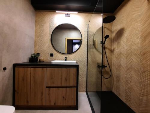 a bathroom with a sink and a mirror at Asti Apartamenty Centrum Stargard in Stargard