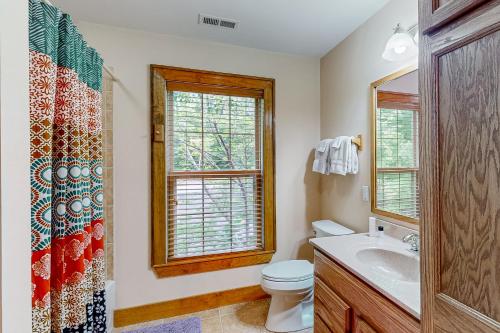 a bathroom with a toilet and a sink and a window at Sweet Home Carolina in Cashiers