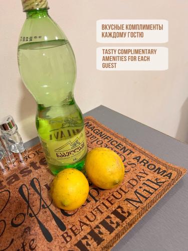 a bottle of alcohol and two lemons on a table at Solo apartments in Ureki