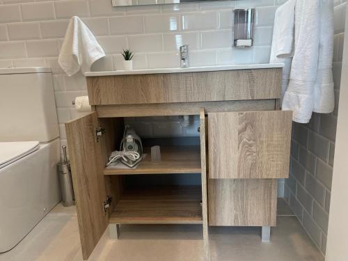 a bathroom with a sink and a wooden cabinet at C10 Exclusiva zona Madrid cerca Bernabéu in Madrid