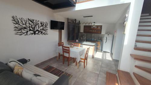 a living room with a table and a kitchen at Flor de Lis in Capilla del Monte