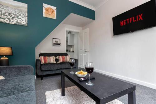 a living room with a table and two glasses of wine at The Normanby! in Normanby