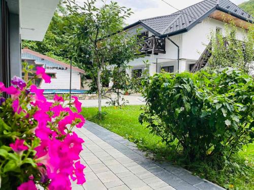 een tuin met roze bloemen en een huis bij Gostynets in Jaremtsje