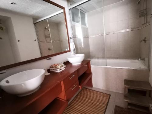a bathroom with two sinks and a tub and a mirror at Amplio y Moderno en Antara, Carso y Embajada EEUU in Mexico City
