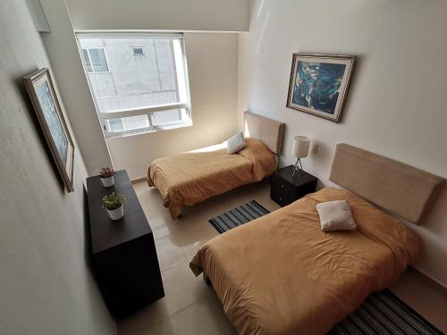 a small room with two beds and a window at Amplio y Moderno en Antara, Carso y Embajada EEUU in Mexico City