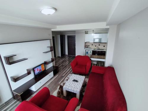 ein Wohnzimmer mit einem roten Sofa und einem Tisch in der Unterkunft البيت المثالي in Kırac