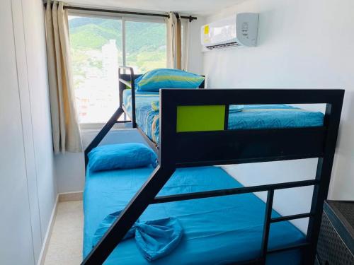 deux lits superposés dans une chambre avec fenêtre dans l'établissement Lujoso, frente a la playa, con terraza y vista al mar ., à Santa Marta