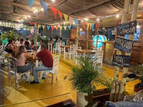 un groupe de personnes assises à une table dans un restaurant dans l'établissement Lujoso, frente a la playa, con terraza y vista al mar ., à Santa Marta