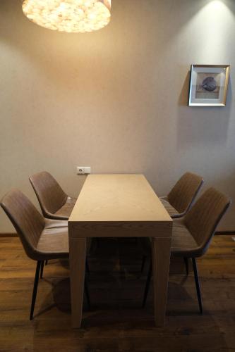 a table with chairs and a light on a wall at Dreamland Oasis apartment Chakvi in Chakvi