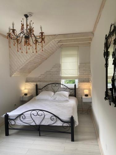 a bedroom with a bed and a chandelier at Hotel Tys in Dilove