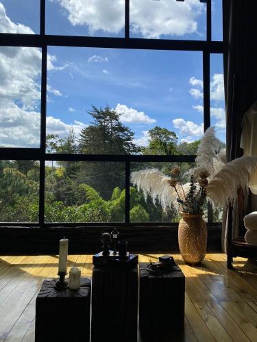 a room with two tables and a large window at Ecoluxury Glamping in San Antonio de Pereira