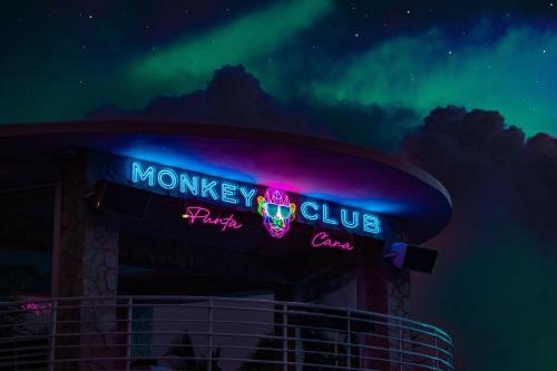 a neon sign for a monkey club at night at Playa Palmera Beach Resort in Punta Cana