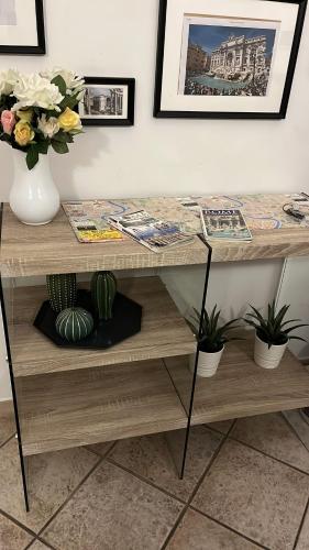 a wooden table with a vase of flowers and plants at Da Adriana al vaticano in Rome