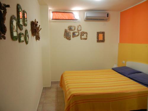 a bedroom with a bed with an orange and yellow blanket at Il Sogno di Alghero - Adults Only in Alghero
