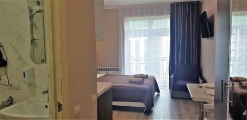 ein Schlafzimmer mit einem Bett und einer Badewanne sowie ein Badezimmer in der Unterkunft Апартаменти в "Арена Віладж" in Poljana