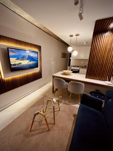 a living room with a table and chairs and a tv at Departamento Moderno ,Torre Blue, Barrio Sur Tucumán in San Miguel de Tucumán