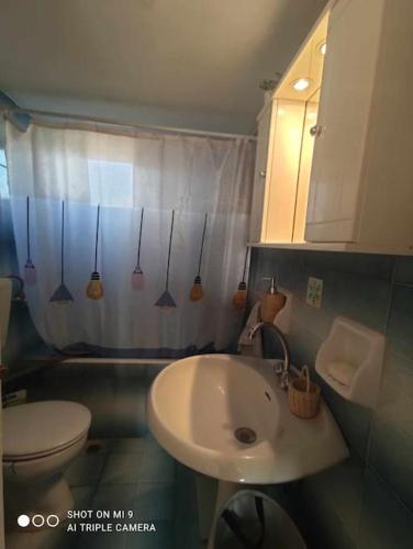 a bathroom with a white sink and a toilet at Summer family house 300m from the beach in Kastraki