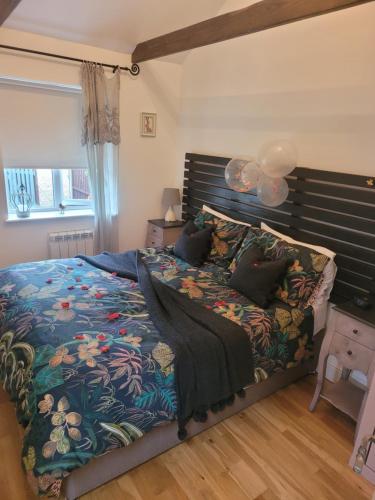 a bedroom with a large bed with a wooden headboard at Birch Cottage with private wood fire hot tub in Harrietsham