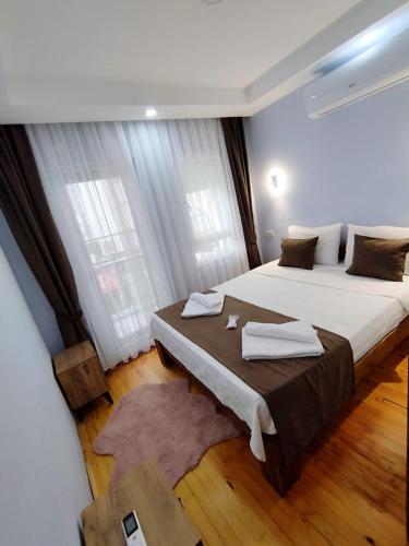 a bedroom with two beds and a large window at Manolyam suit 5 .1+1 in Kaş