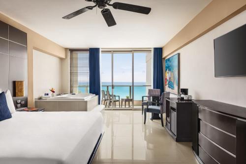 a bedroom with a bed and a bathroom with a tub at Seadust Cancun Family Resort - All Inclusive in Cancún