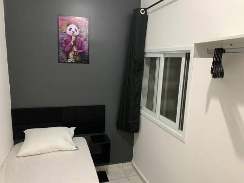 1 dormitorio con 1 cama y una foto en la pared en Loft moderno próximo Aeroporto e UPF, en Passo Fundo