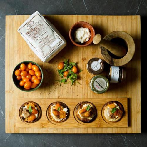 a wooden cutting board with food on top of it at Rinaldo Holiday Home in Sambuca di Sicilia