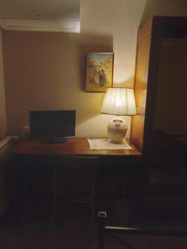 a desk with a lamp and a monitor on it at San Nicolò Holiday Home in Montalbano Elicona