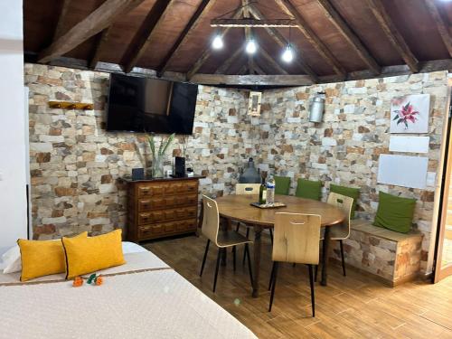 a dining room with a table and chairs and a tv at Tradicional Casa Canaria con piscina y vistas al Teide in Icod de los Vinos