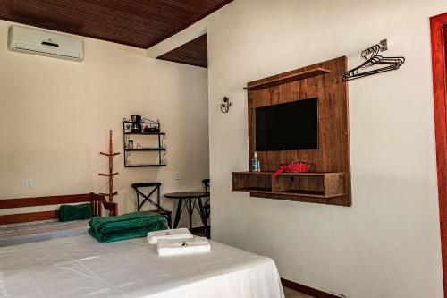 a room with a bed and a tv on a wall at Villa Zanotto Piri in Pirenópolis