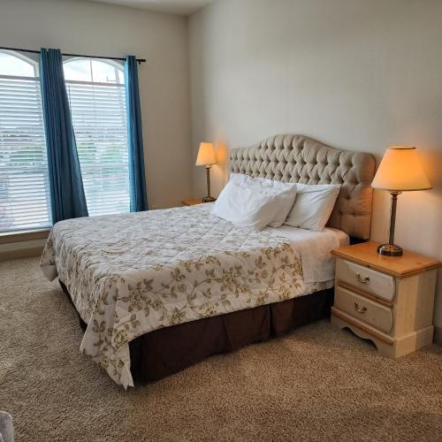 a bedroom with a large bed and two windows at Domain at Kirby in Houston