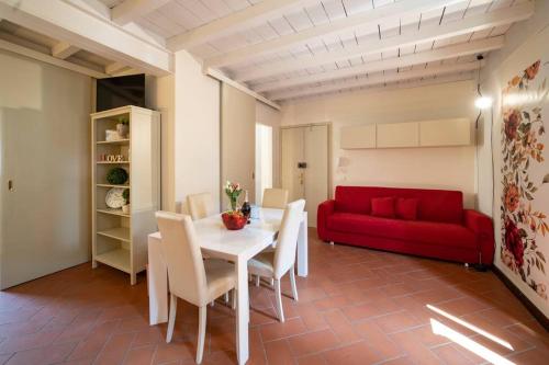 sala de estar con mesa y sofá rojo en Odi et Amo - Luxury Love en Brescia