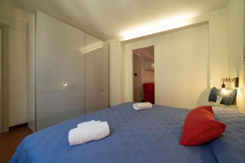 a bedroom with a blue bed with red pillows at Odi et Amo - Luxury Love in Brescia