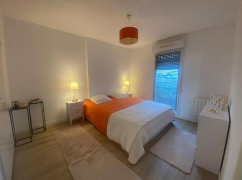 塞納河畔埃皮奈的住宿－"Olympic Sweet Home" Paris Stade de France，一间卧室配有橙色的床和窗户。