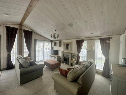 sala de estar con 2 sofás y chimenea en Luxury 6-8 Berth Lodge, en New Milton