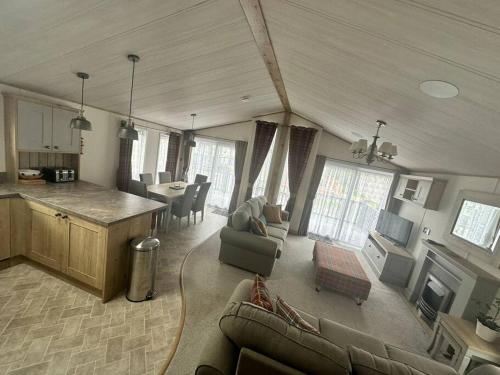 a living room with a couch and a kitchen at Luxury 6-8 Berth Lodge in New Milton