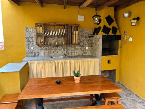 uma cozinha com uma mesa de madeira e um lavatório em Tradicional Casa Canaria con piscina y vistas al Teide em Icod de los Vinos