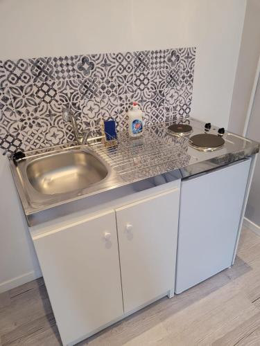 une cuisine avec un évier et un plan de travail dans l'établissement Studio au centre-ville de Sens, à Sens
