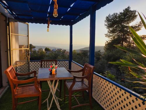 a table and chairs on the back porch of a house at Beit Philodemus in Um Qeis