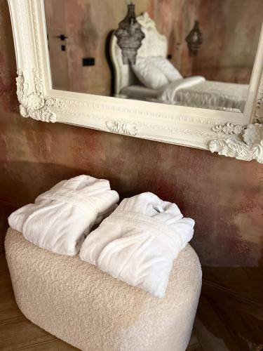 two white towels sitting on a bench in front of a mirror at ALL - Amberstone Lux Loft in Klaipėda