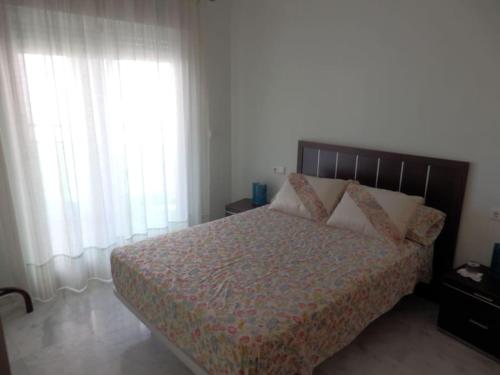 een slaapkamer met een bed en 2 grote ramen bij Precioso apartamento en complejo residencial con piscina,barbacoa y pista de padel. in Villajoyosa