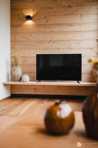 a living room with a flat screen tv in a wall at Stoacherhof Apartments in Matrei am Brenner