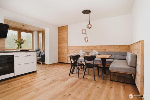 a kitchen and living room with a table and a couch at Stoacherhof Apartments in Matrei am Brenner
