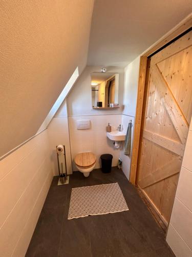 een badkamer met een houten toilet en een wastafel bij Rustikale alte Fachwerk Burg in Winden bei Nassau in Winden