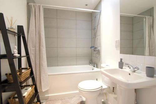 a bathroom with a sink and a toilet and a bath tub at Perfect 1 bed flat in London