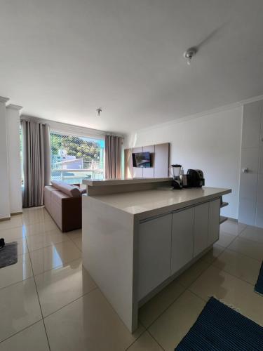 a kitchen with a counter and a couch in a room at Apartamento Balneário Camboriú in Balneário Camboriú